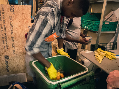 Employee composting in a large bokashi bin