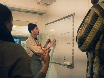 Facilitator setting up a tracking system on a whiteboard with employees