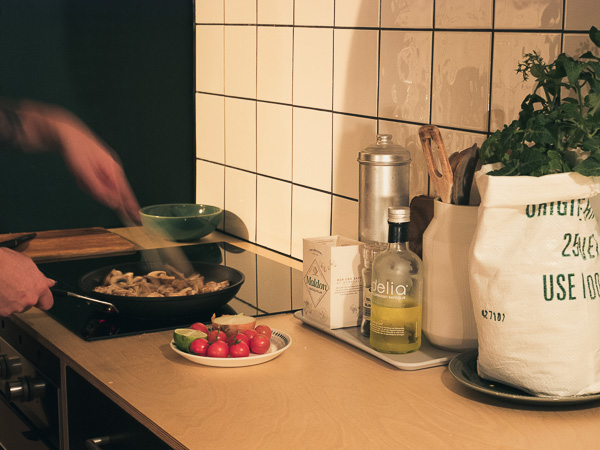 Customer cooking a meal with the tomatoes harvested from the growing kit