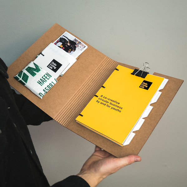 The report, handbook and photo held in a laser cut cardboard cover with grain bag pouches.